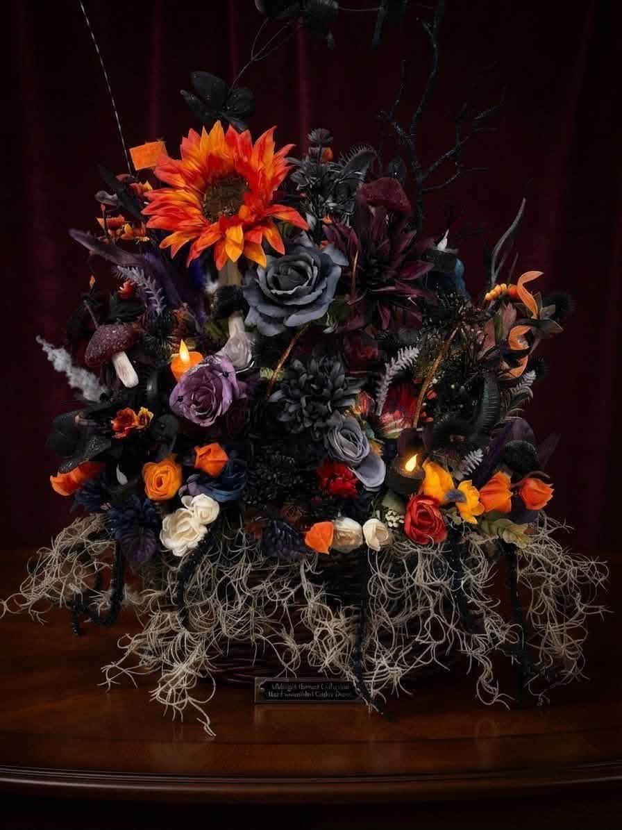 Orange sunflower and gray and purple decorative roses with black branches and trailing moss